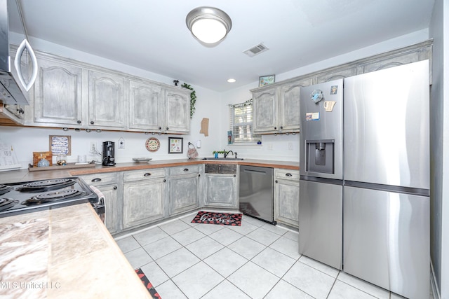 kitchen with sink, light tile patterned floors, and stainless steel appliances