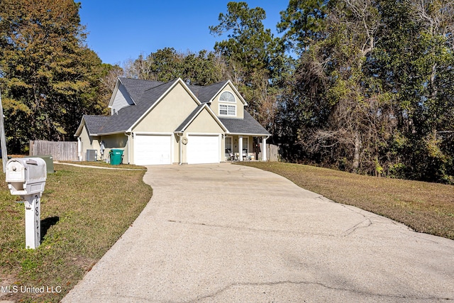 view of front of home with central AC unit, a garage, and a front lawn