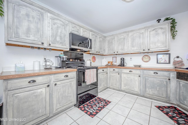 kitchen with black / electric stove and light tile patterned floors