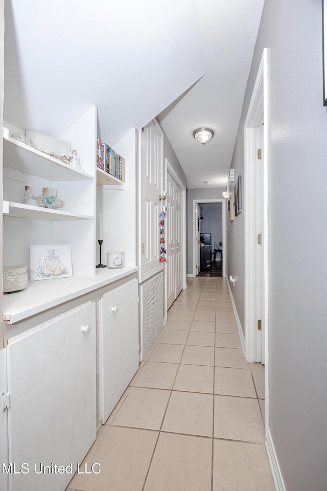 hall featuring light tile patterned floors