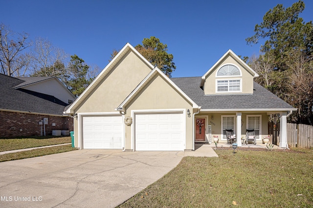 view of property with covered porch, a garage, and a front yard