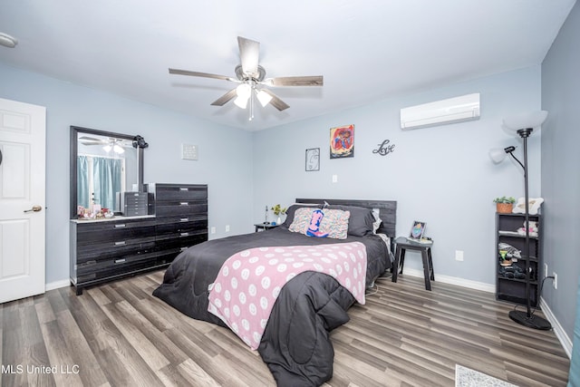 bedroom with a wall mounted AC, ceiling fan, and hardwood / wood-style flooring