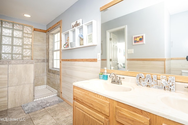 bathroom with a tile shower, tile patterned floors, and vanity