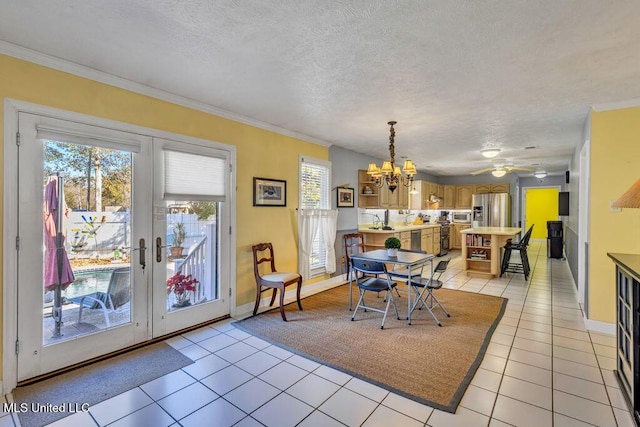 dining area featuring light tile patterned floors, ceiling fan with notable chandelier, and crown molding