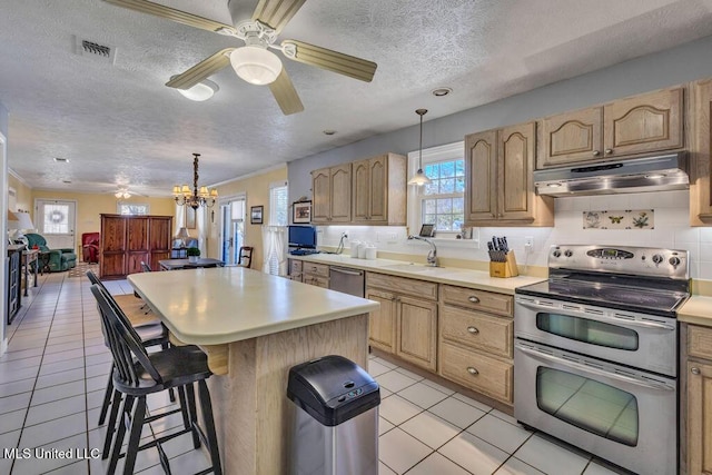 kitchen featuring a center island, a breakfast bar, sink, appliances with stainless steel finishes, and a textured ceiling