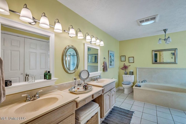 bathroom featuring a textured ceiling, tile patterned flooring, vanity, a bathtub, and toilet