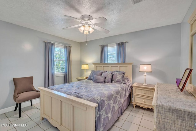 tiled bedroom featuring ceiling fan, multiple windows, and a textured ceiling