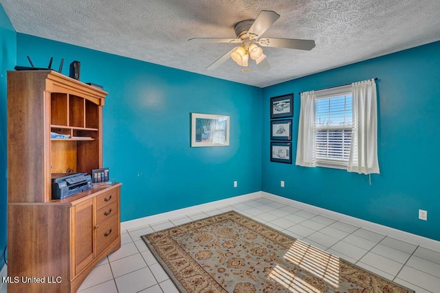 unfurnished office with a textured ceiling, ceiling fan, and light tile patterned flooring