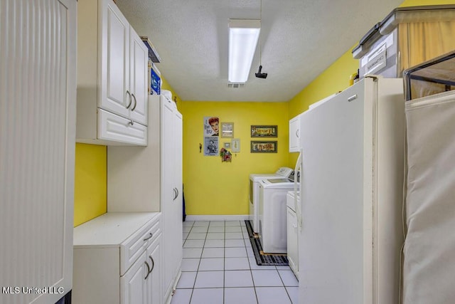 laundry room featuring washer and dryer, cabinets, a textured ceiling, and light tile patterned flooring