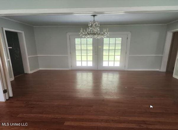 unfurnished dining area with french doors, dark hardwood / wood-style floors, and ornamental molding