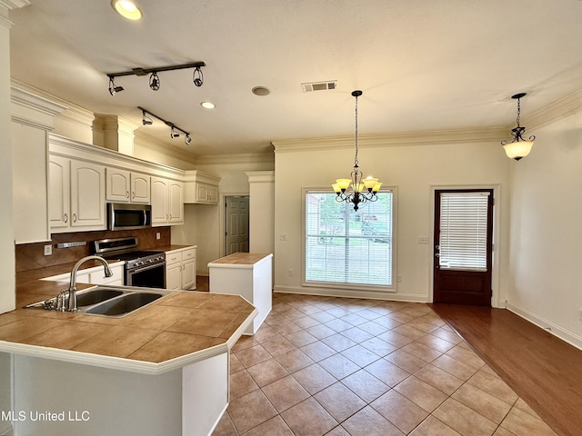 302 Bedford Ct, Brandon, MS 39047 - kitchen with appliances with stainless steel finishes, a sink, a peninsula, light tile patterned floors, and a chandelier
