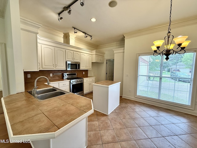 302 Bedford Ct, Brandon, MS 39047 - kitchen with stainless steel appliances, a sink, light tile patterned flooring, track lighting, and a chandelier