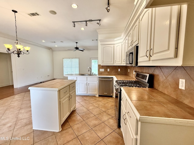 302 Bedford Ct, Brandon, MS 39047 - kitchen featuring appliances with stainless steel finishes, a sink, a peninsula, light tile patterned flooring, and recessed lighting