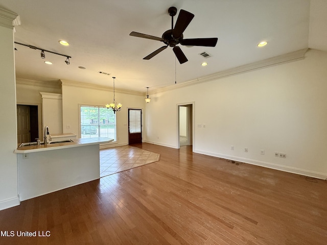 302 Bedford Ct, Brandon, MS 39047 - unfurnished living room with crown molding, ceiling fan, a sink, a chandelier, and wood finished floors