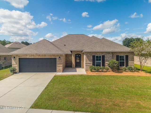 view of front of property featuring a garage and a front lawn