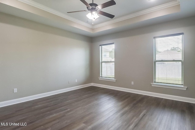 spare room with dark hardwood / wood-style floors, ceiling fan, ornamental molding, and a tray ceiling