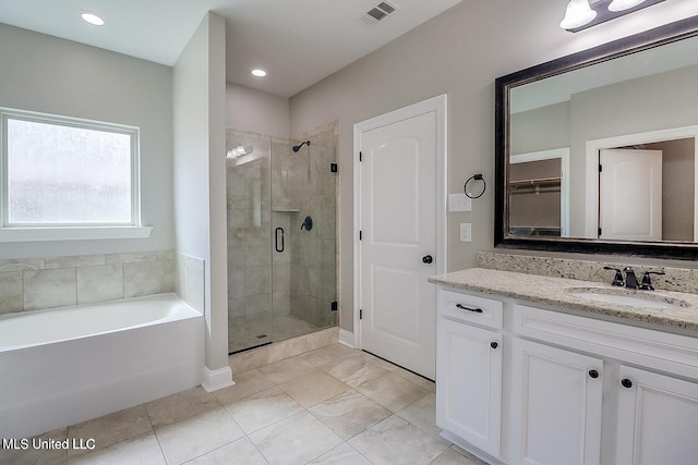 bathroom featuring vanity and independent shower and bath