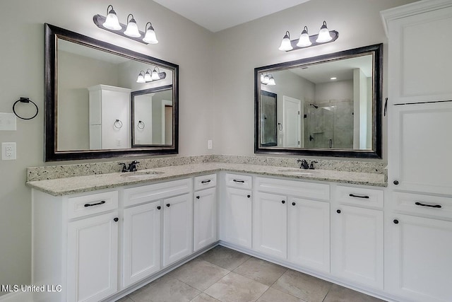 bathroom featuring tile patterned flooring, vanity, and a shower with shower door