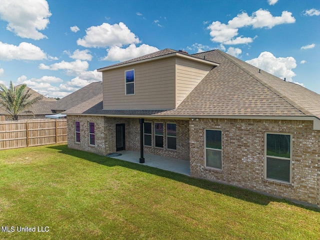 back of house with a patio area and a yard