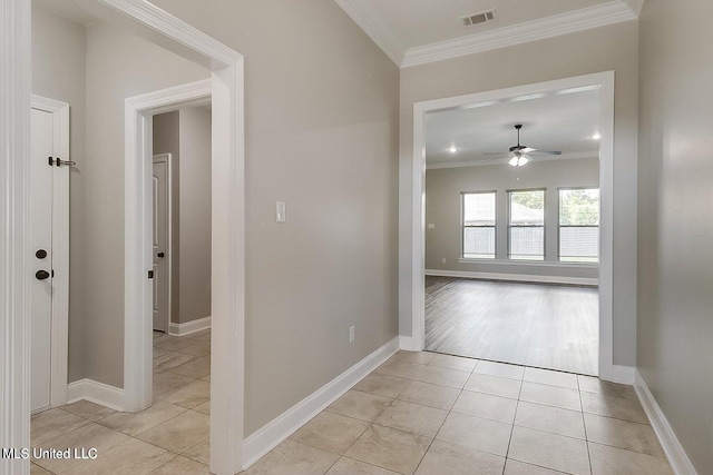 hall with light tile patterned floors and ornamental molding