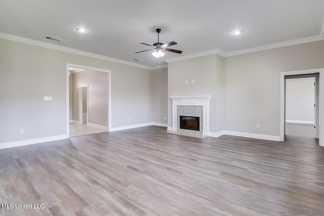 unfurnished living room featuring crown molding, a high end fireplace, and light hardwood / wood-style flooring