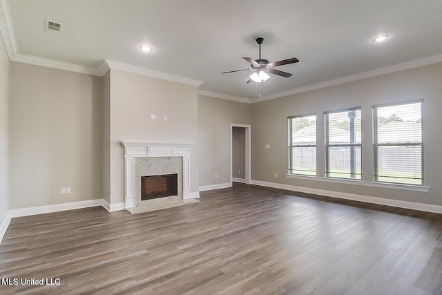 unfurnished living room featuring a high end fireplace, hardwood / wood-style flooring, ceiling fan, and ornamental molding