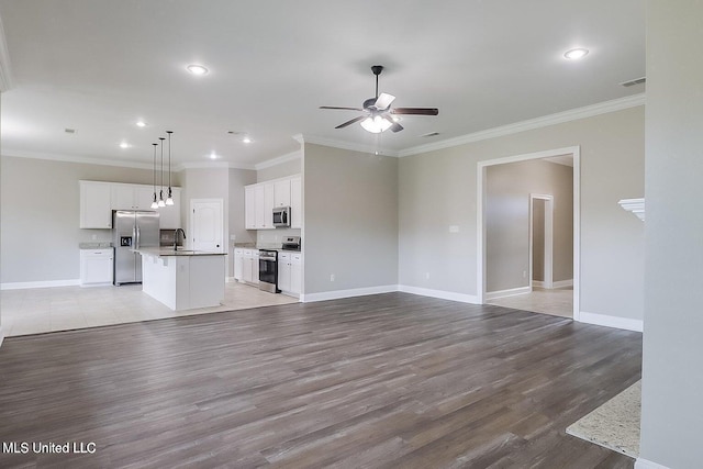 unfurnished living room with crown molding, sink, ceiling fan, and light hardwood / wood-style floors