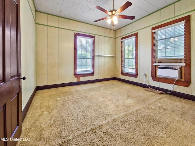 carpeted spare room with baseboards, ceiling fan, and cooling unit