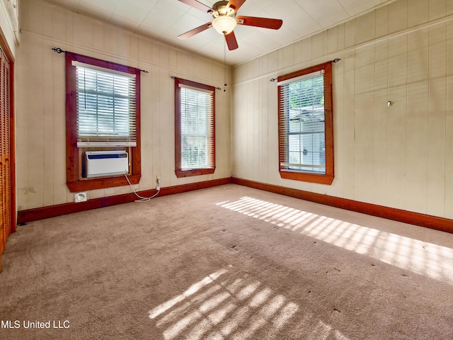 carpeted spare room featuring baseboards, cooling unit, and a ceiling fan