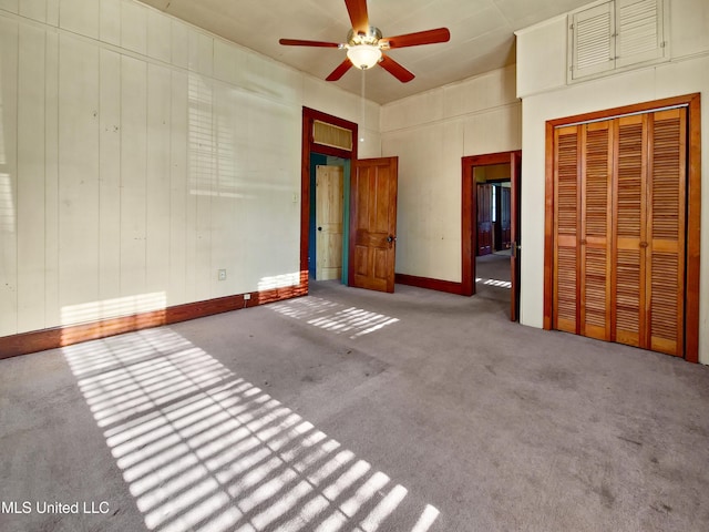 unfurnished bedroom with a closet, baseboards, ceiling fan, and carpet flooring