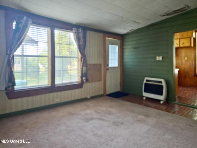 interior space featuring heating unit and wood walls