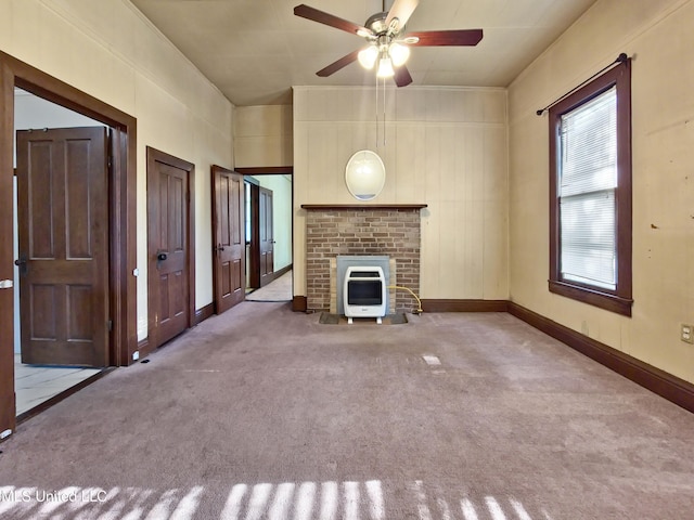 unfurnished living room featuring ceiling fan, a fireplace, carpet floors, baseboards, and heating unit