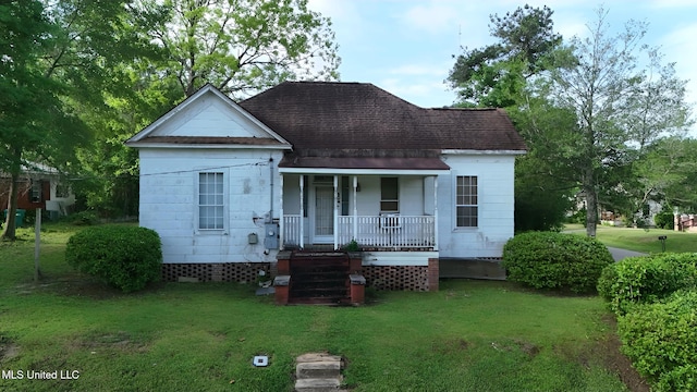 back of property featuring roof with shingles, a yard, a porch, and crawl space