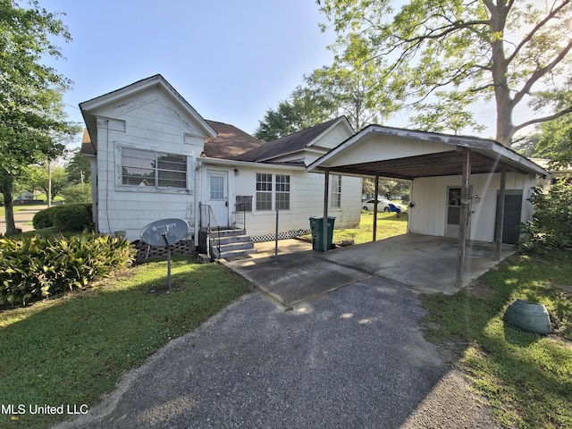 view of front of property featuring roof with shingles, driveway, a front yard, and a carport