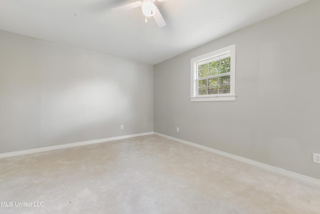 spare room featuring ceiling fan, baseboards, and light colored carpet