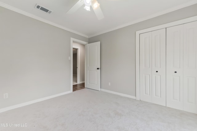 unfurnished bedroom with carpet floors, baseboards, visible vents, and crown molding