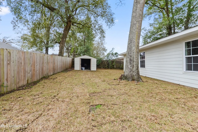 view of yard featuring an outbuilding, a fenced backyard, and a storage unit