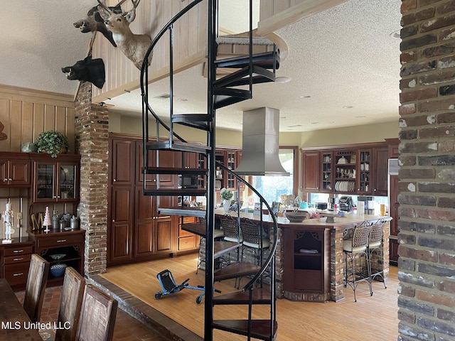 5 Lombardy Rd, Drew, MS 38737 - interior space with island exhaust hood, dark brown cabinets, a textured ceiling, and light wood-type flooring