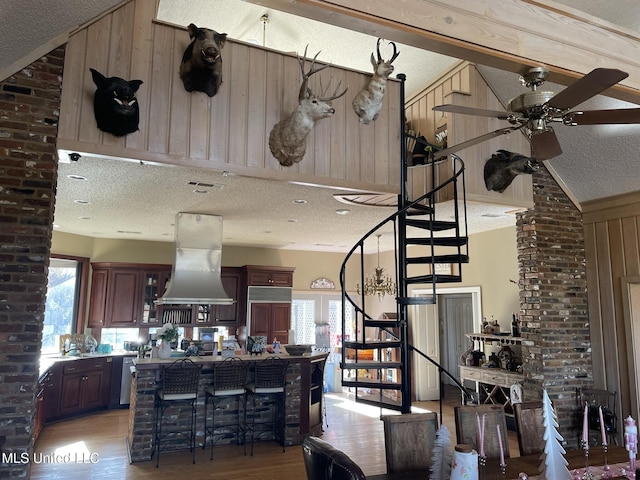 5 Lombardy Rd, Drew, MS 38737 - kitchen with island exhaust hood, a healthy amount of sunlight, wooden walls, and a textured ceiling