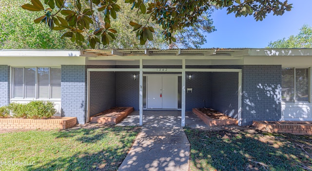 entrance to property featuring a lawn