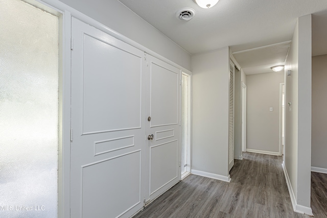 corridor with hardwood / wood-style flooring