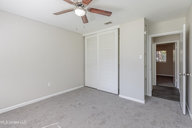 unfurnished bedroom featuring ceiling fan, a closet, and light carpet