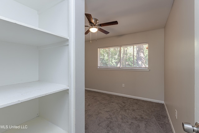 interior space featuring ceiling fan and dark carpet