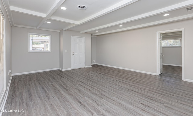 spare room featuring beam ceiling and hardwood / wood-style floors