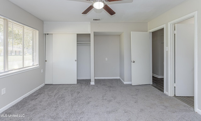 unfurnished bedroom featuring a closet, light colored carpet, and ceiling fan