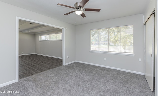 unfurnished room with dark carpet and ceiling fan