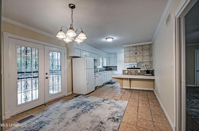 kitchen featuring white refrigerator, white cabinetry, ornamental molding, and french doors