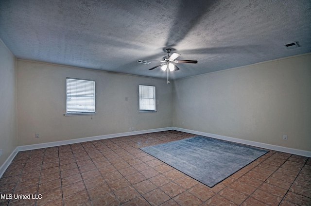 tiled empty room featuring a textured ceiling and ceiling fan