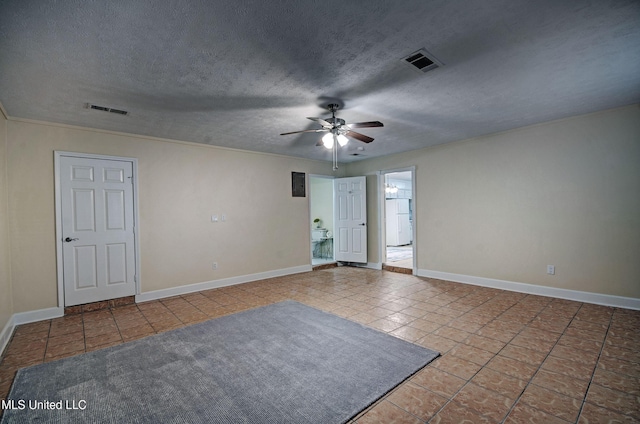 empty room featuring light tile patterned flooring, ceiling fan, and a textured ceiling