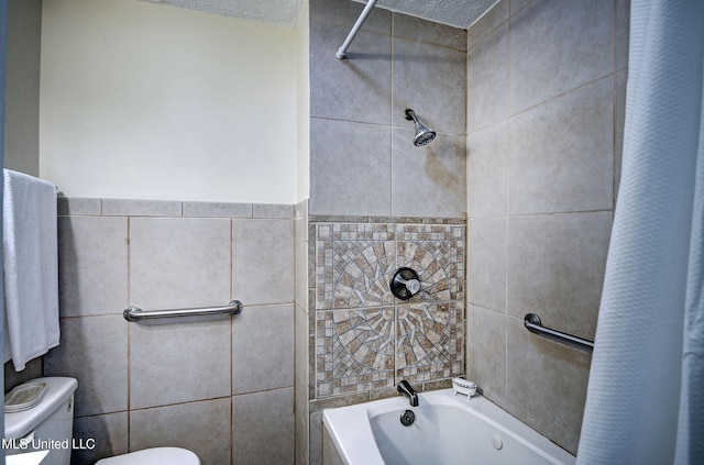 bathroom with toilet, a textured ceiling, tile walls, and shower / bath combo